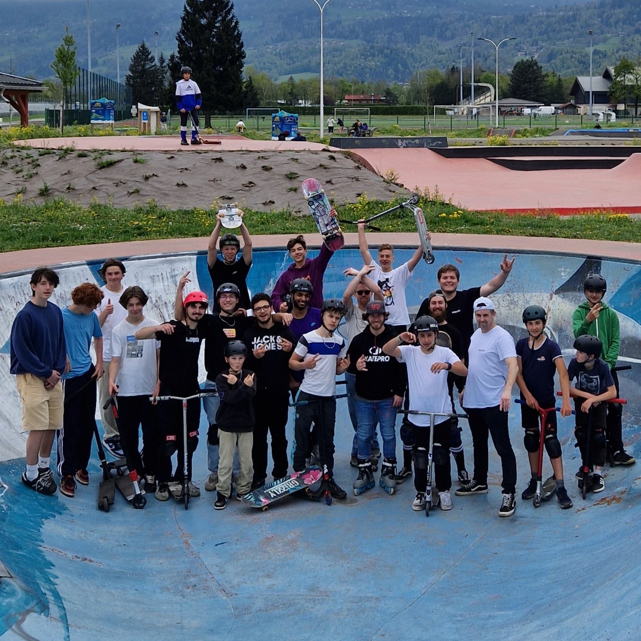 Le groupe RIDEART réuni dans le bowl d'un skatepark, skateboards, rollers et trottinettes mêlés