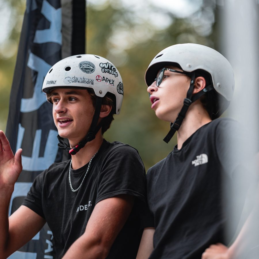 Deux jeunes riders casqués discutant pendant un contest