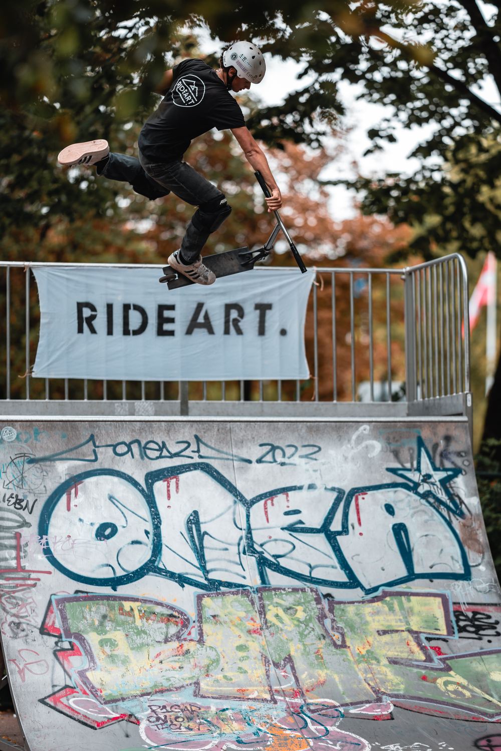 Rider en trottinette devant la banderole RIDEART