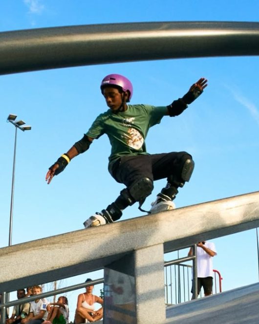 Gabriel Lebon, casque violet, en slide sur un rail de skatepark